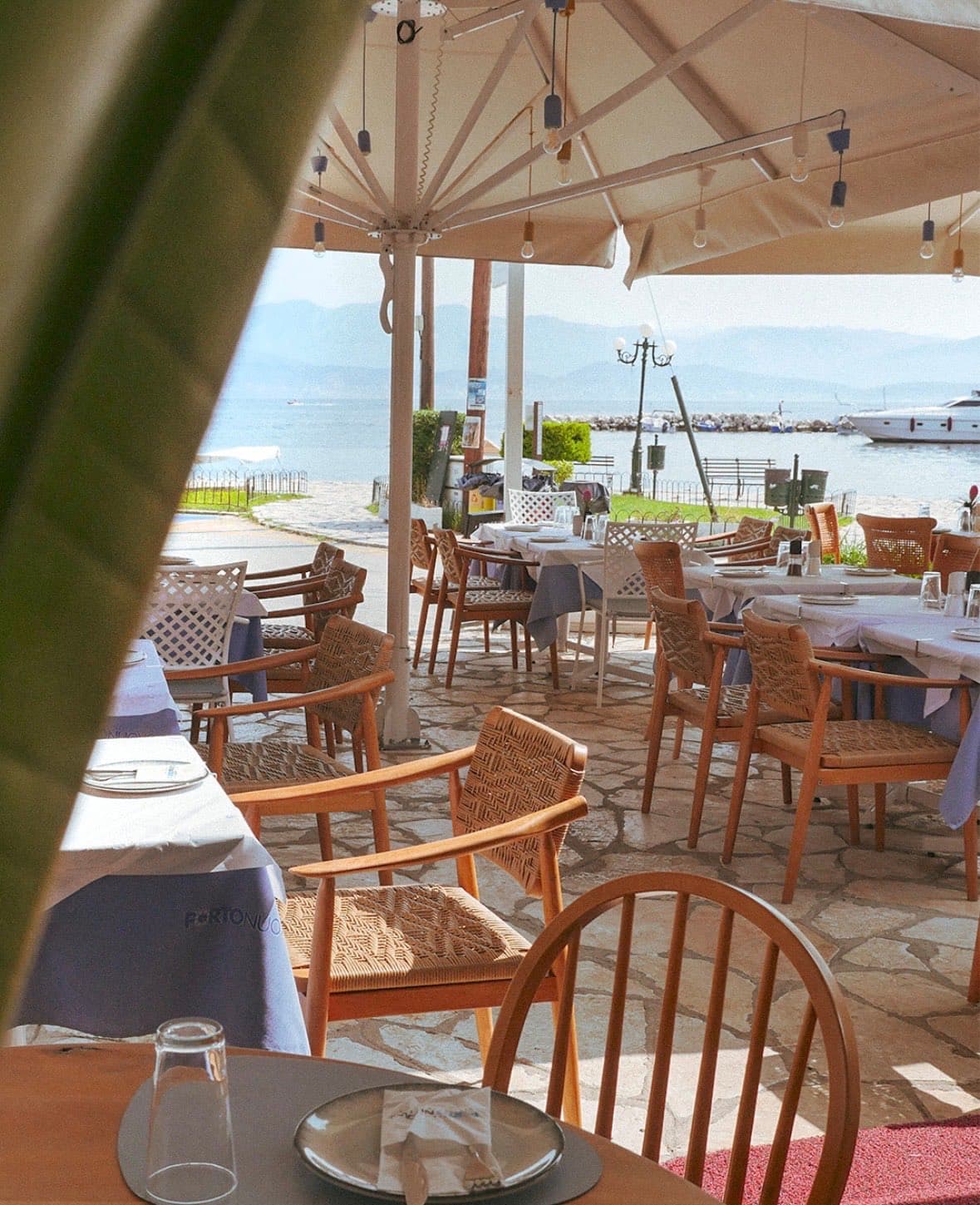 Porto Nuovo's terrace on Kassiopi harbour — the table is waiting